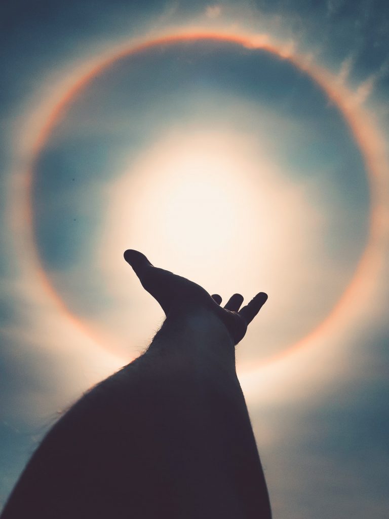 a hand holding a rainbow