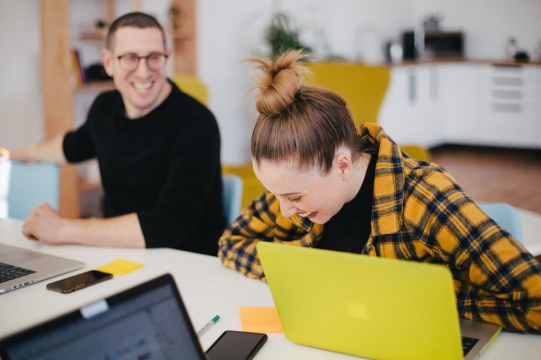 a man and a woman looking at a laptop