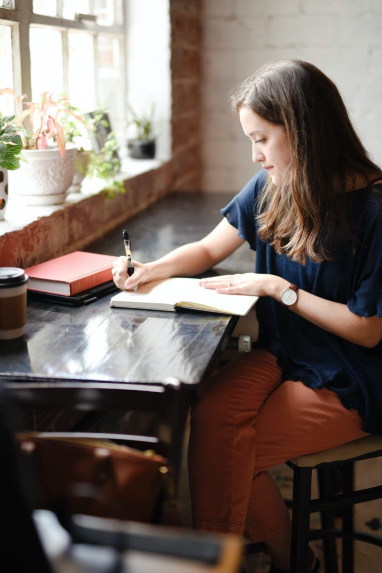 a woman sitting at a table writing